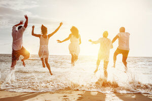 people jumping for joy on the beach as a result of behavioral therapy