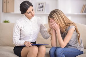 upset woman on therapist's couch receives trauma therapy