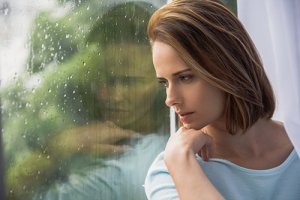 woman looking out window needs adderall addiction treatment