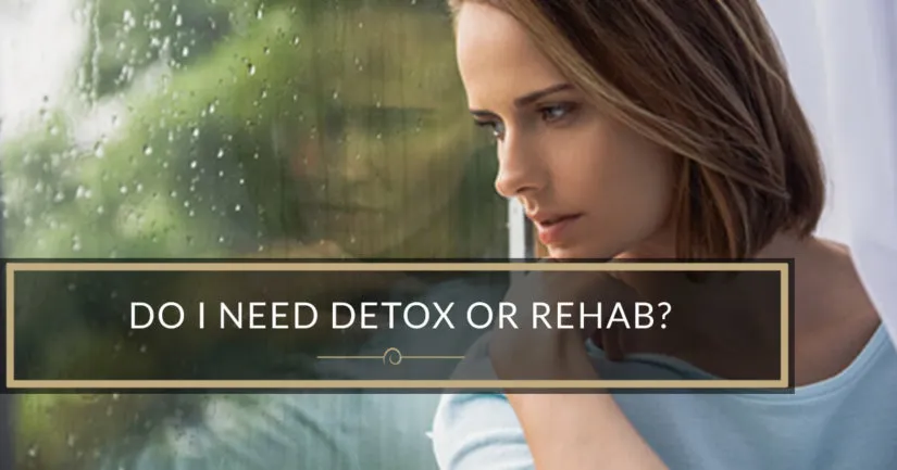 A woman looking thoughtfully out of a rain-streaked window.